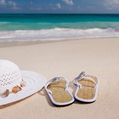 white-straw-hat-and-flip-flops-on-beach